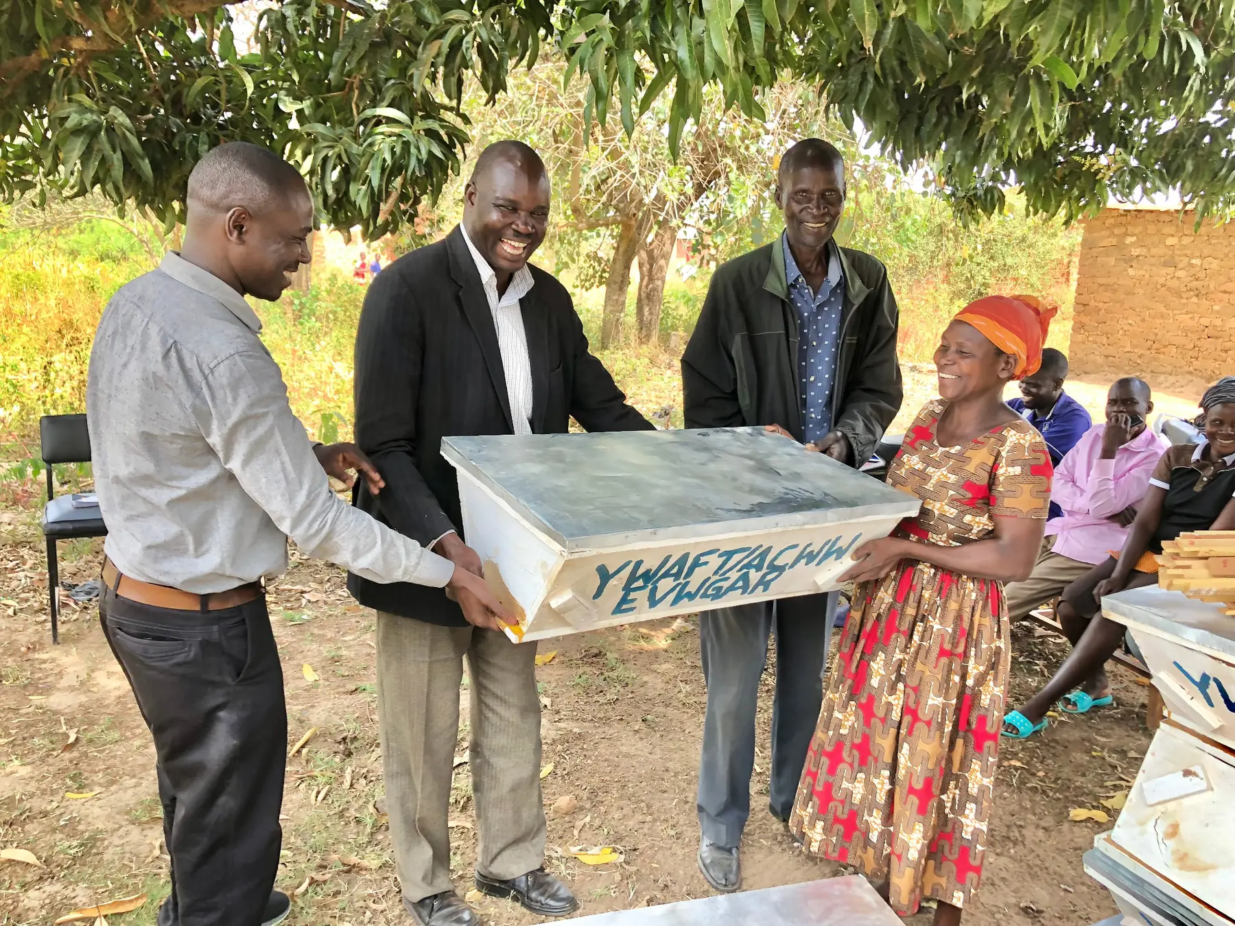 Community members receive beehives through a YWAFT women’s economic-empowerment initiative
