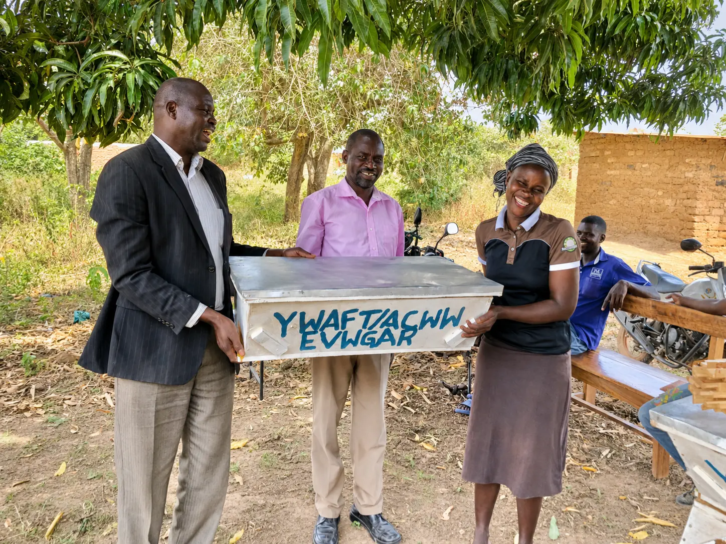 Community members receiving a beehive through the EVWGAR project