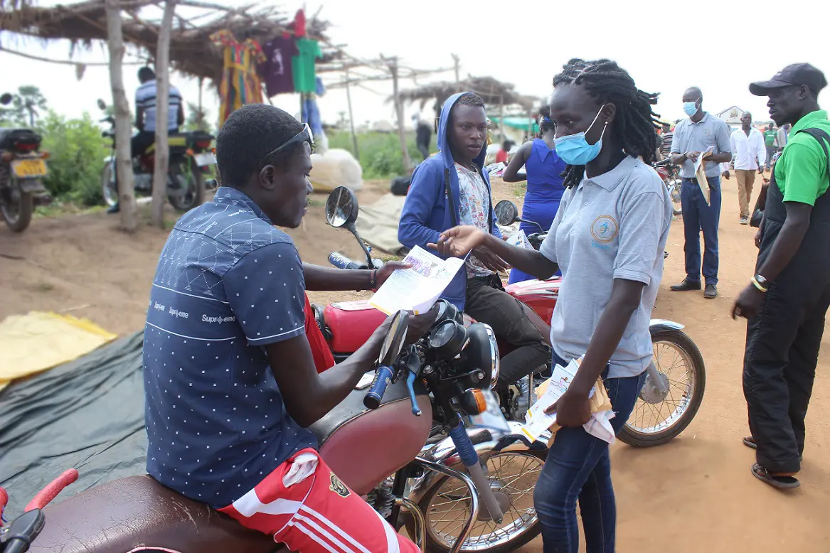 A YWAFT facilitator discusses rights and inclusion with community members at a public market