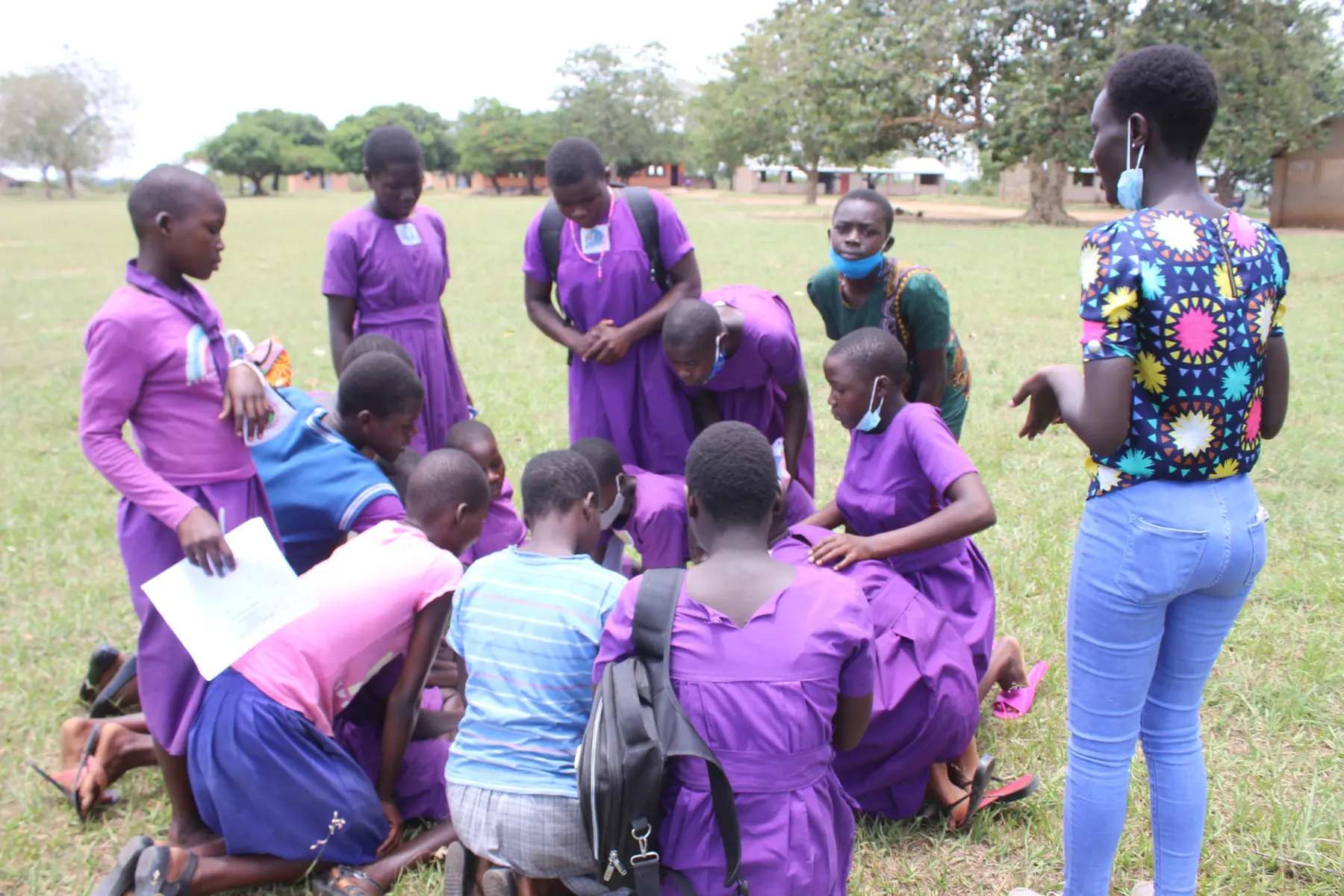 Young women and facilitators participate in a community learning activity