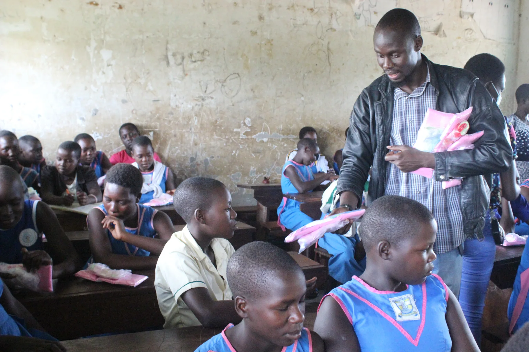YWAFT staff distributing menstrual dignity materials to schoolgirls