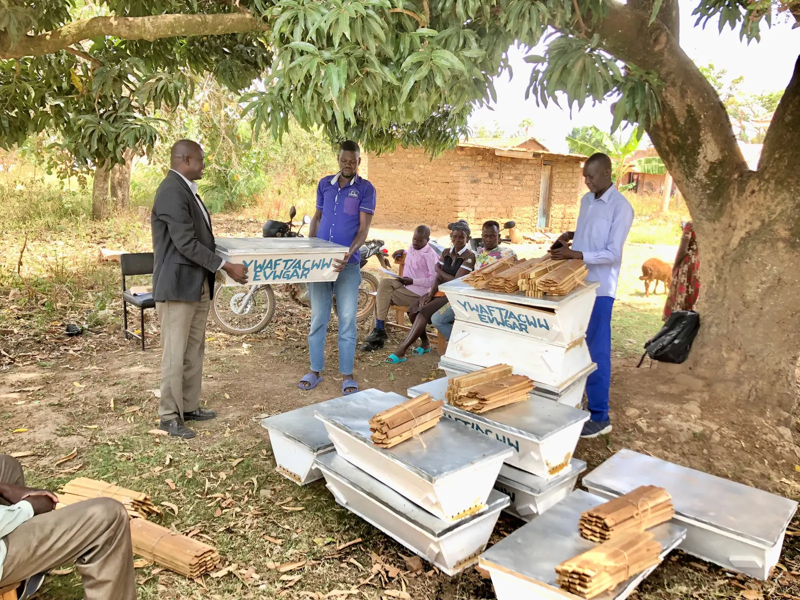 Community members receiving beehives for a livelihood initiative